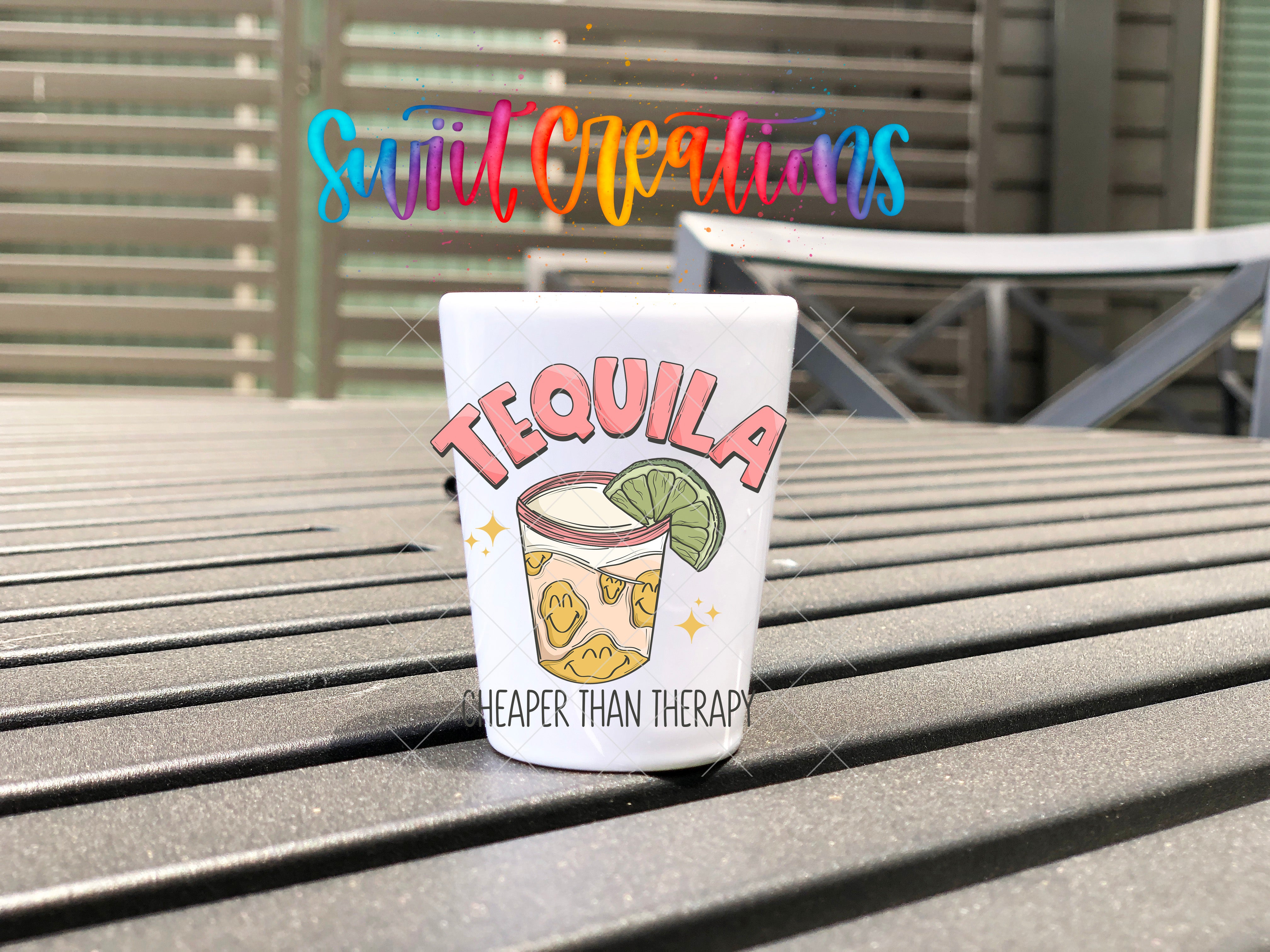 a cup of tequila sitting on top of a wooden table