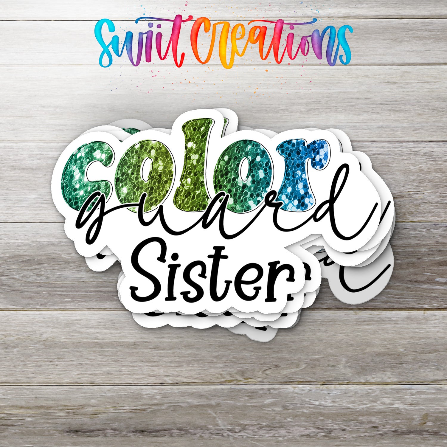 A stack of colorful stickers with the text "Color guard Sister" written on them, placed on a wooden surface.