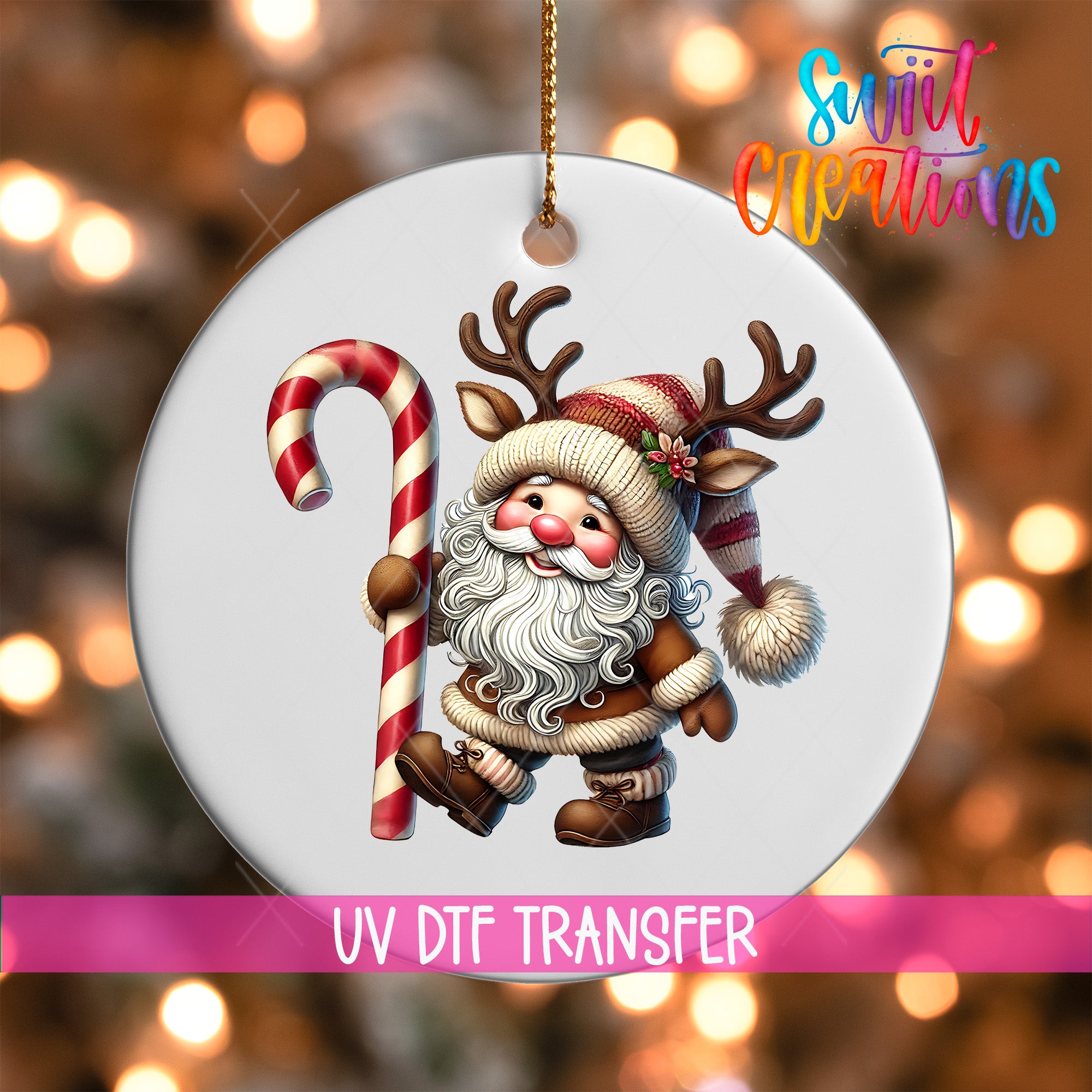 A white ornament with a Santa Claus figure holding a candy cane and antlers, with a pink ribbon below the ornament.