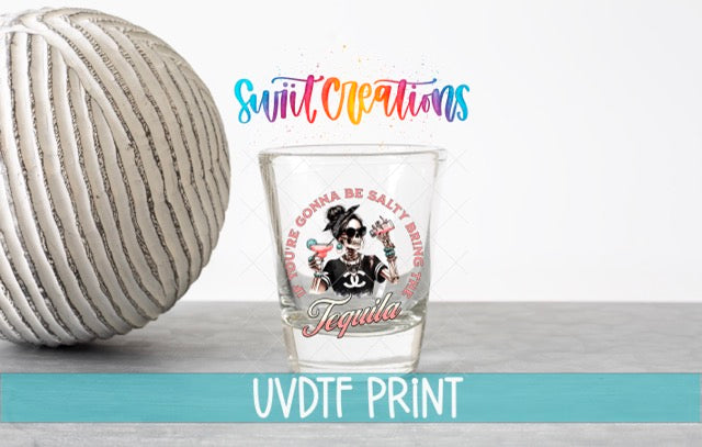 a ball of yarn next to a shot glass