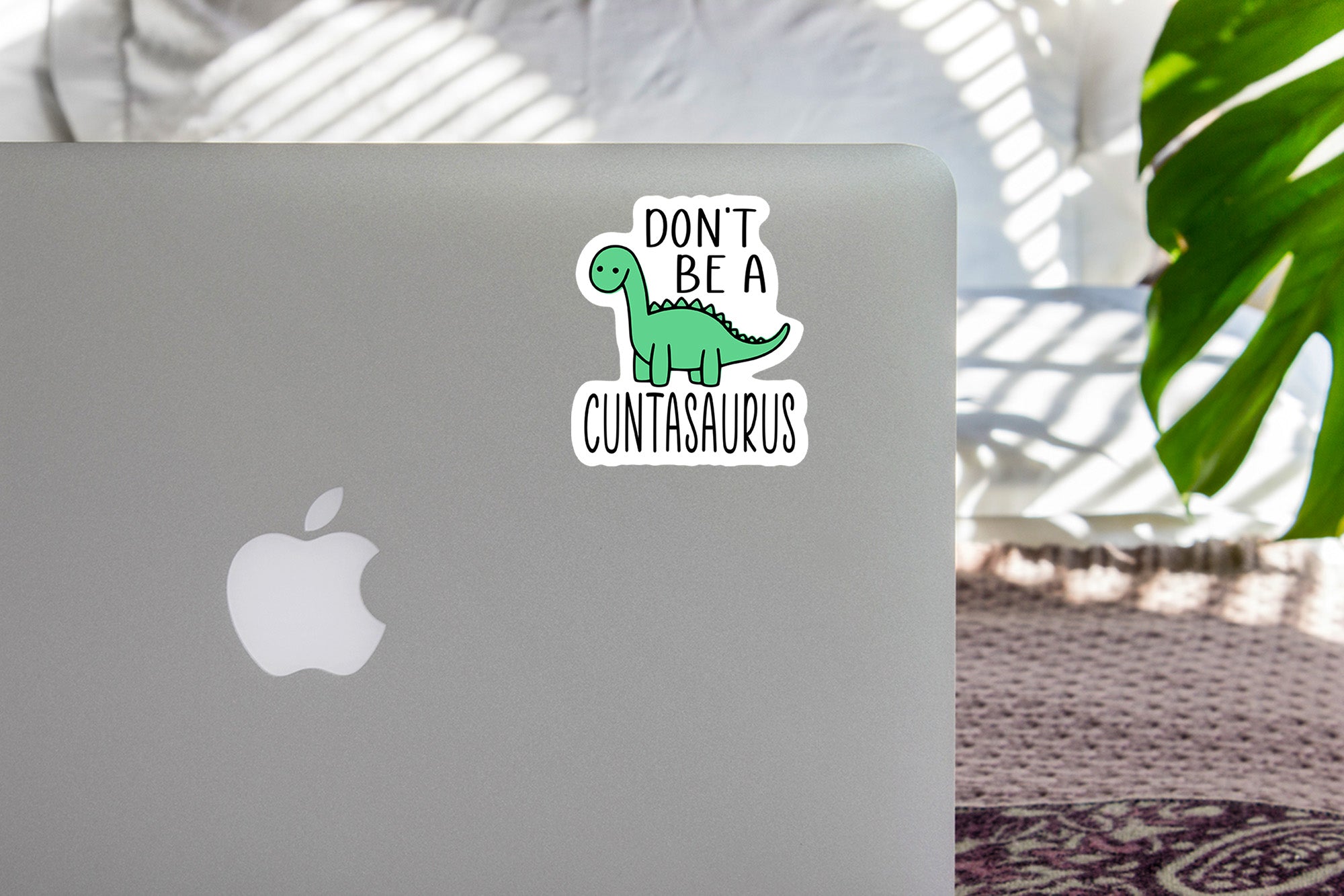 a laptop with a sticker of a dinosaur on it