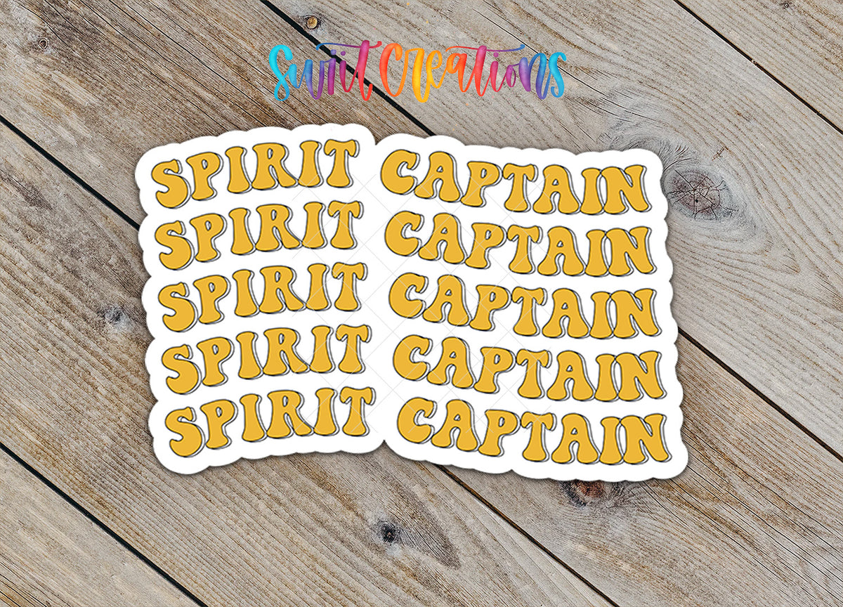 a collection of stickers with the word "CAPTAIN" written on them, arranged on a wooden surface.