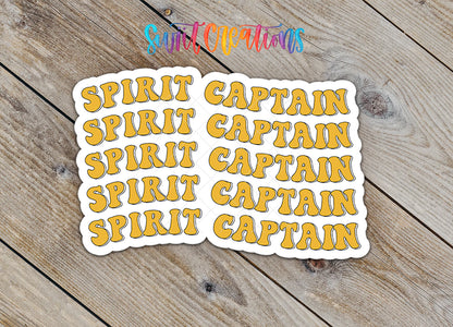 a collection of stickers with the word "CAPTAIN" written on them, arranged on a wooden surface.
