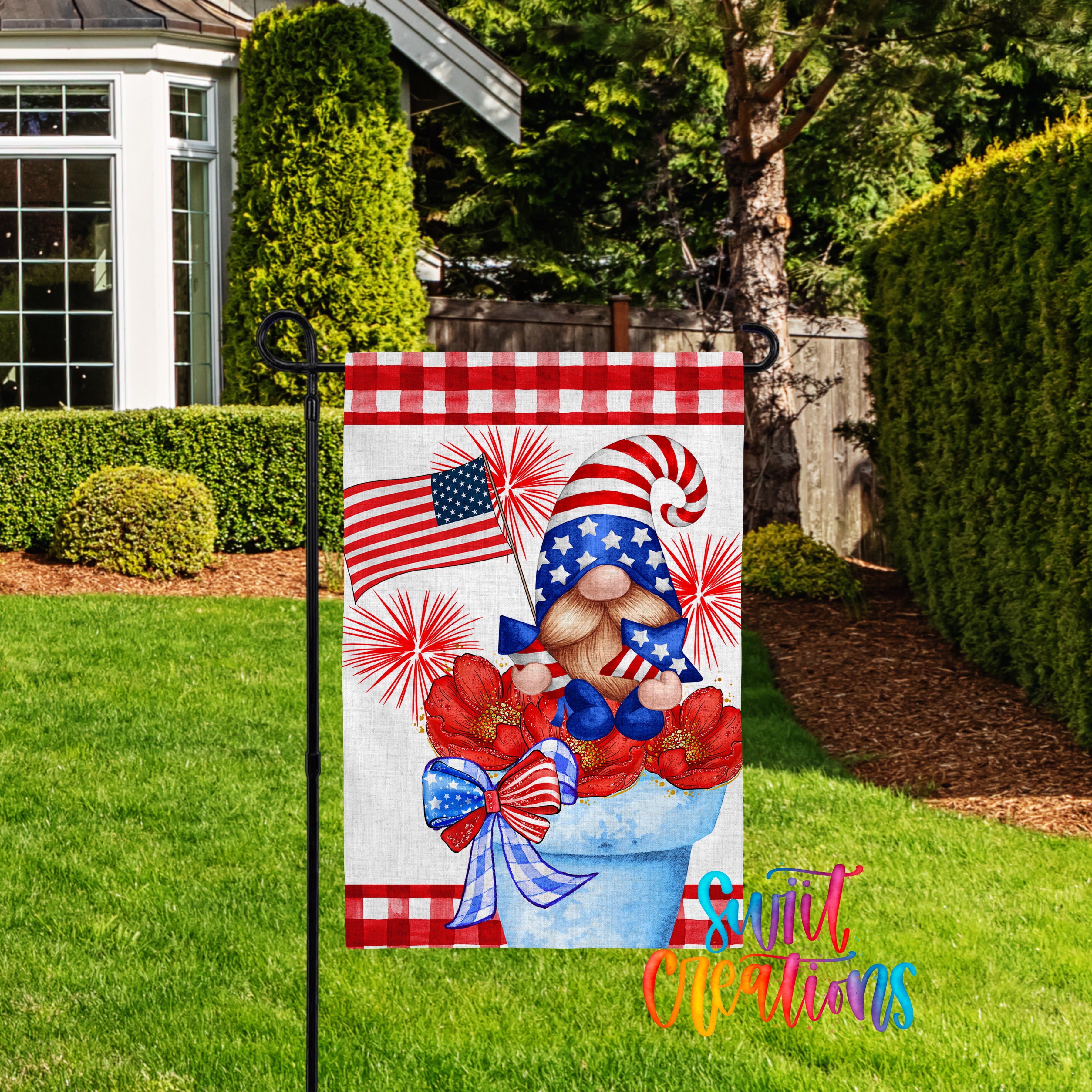 A patriotic-themed garden flag featuring a gnome holding an American flag and flowers, set against a backdrop of a house and trees.