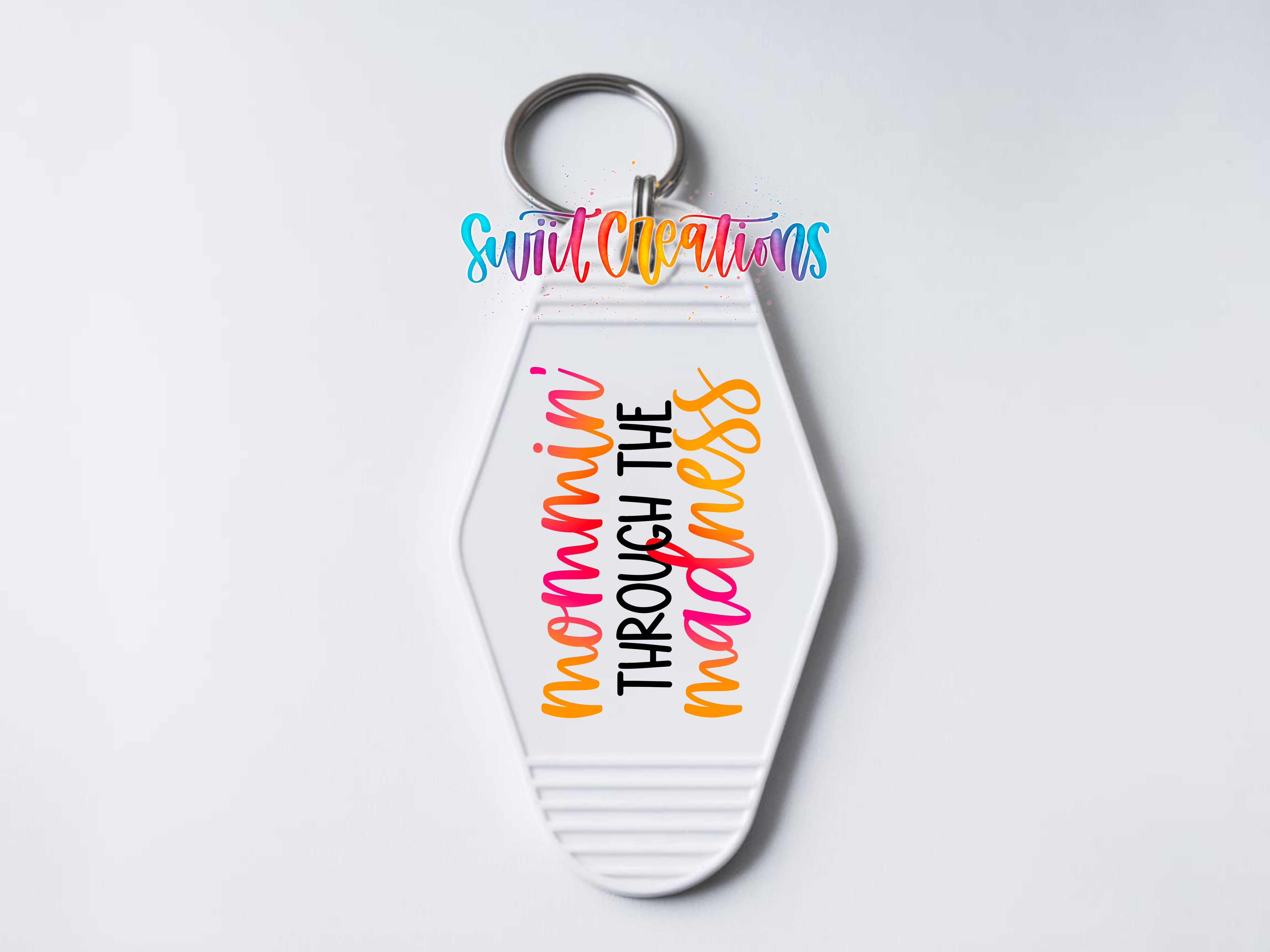 A keychain with the text "nommini through the madness" printed on it.