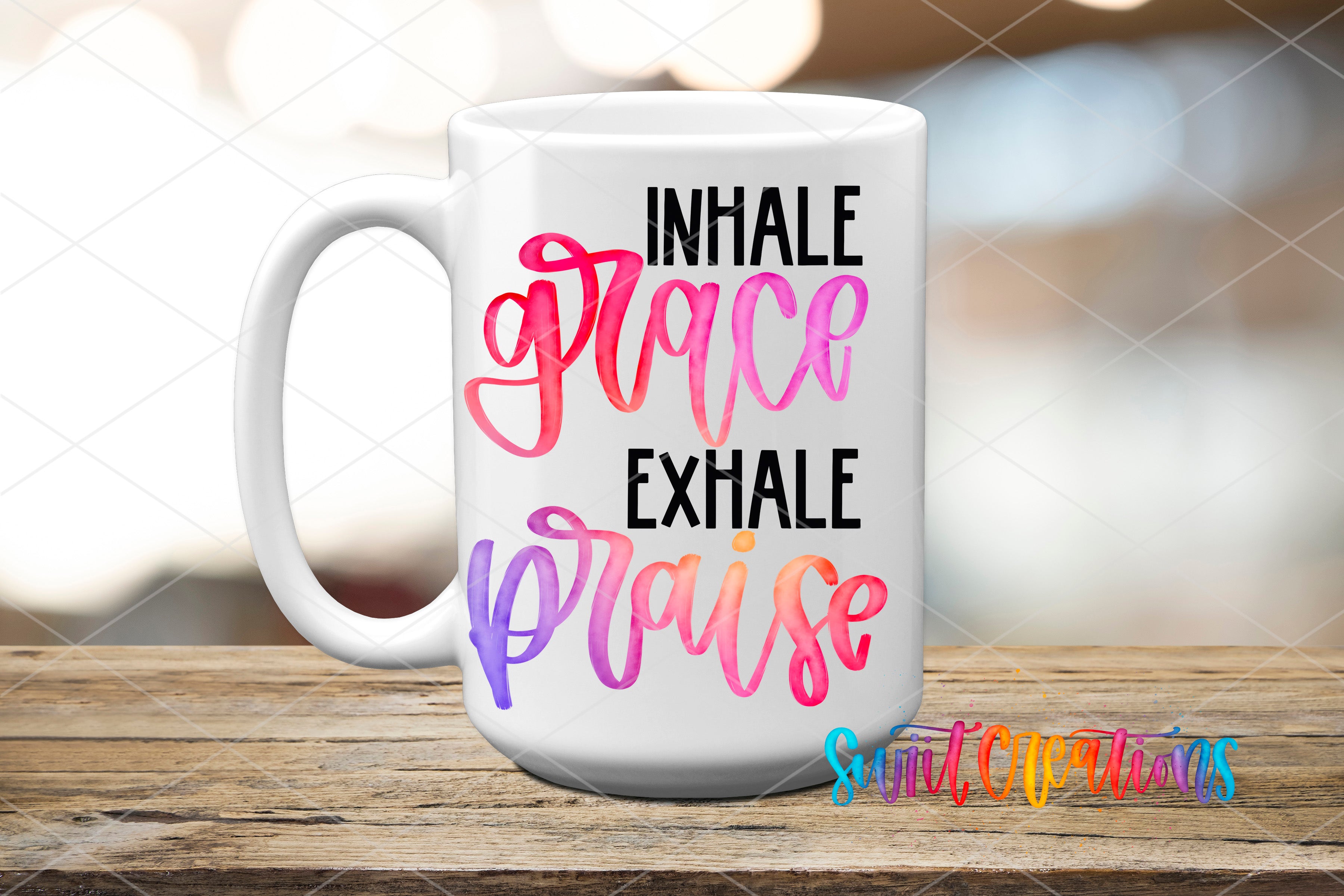 A white mug with colorful text that says "INHALE GRACE EXHAKE PRAISE" printed on it.