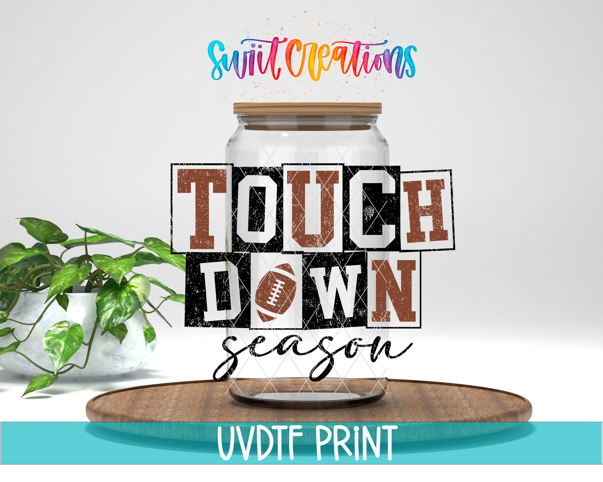 a large glass jar with the text "TOUCH DOWN" written on it, along with the text "season" below it. The jar is placed on a wooden surface, and there is a potted plant in the background.