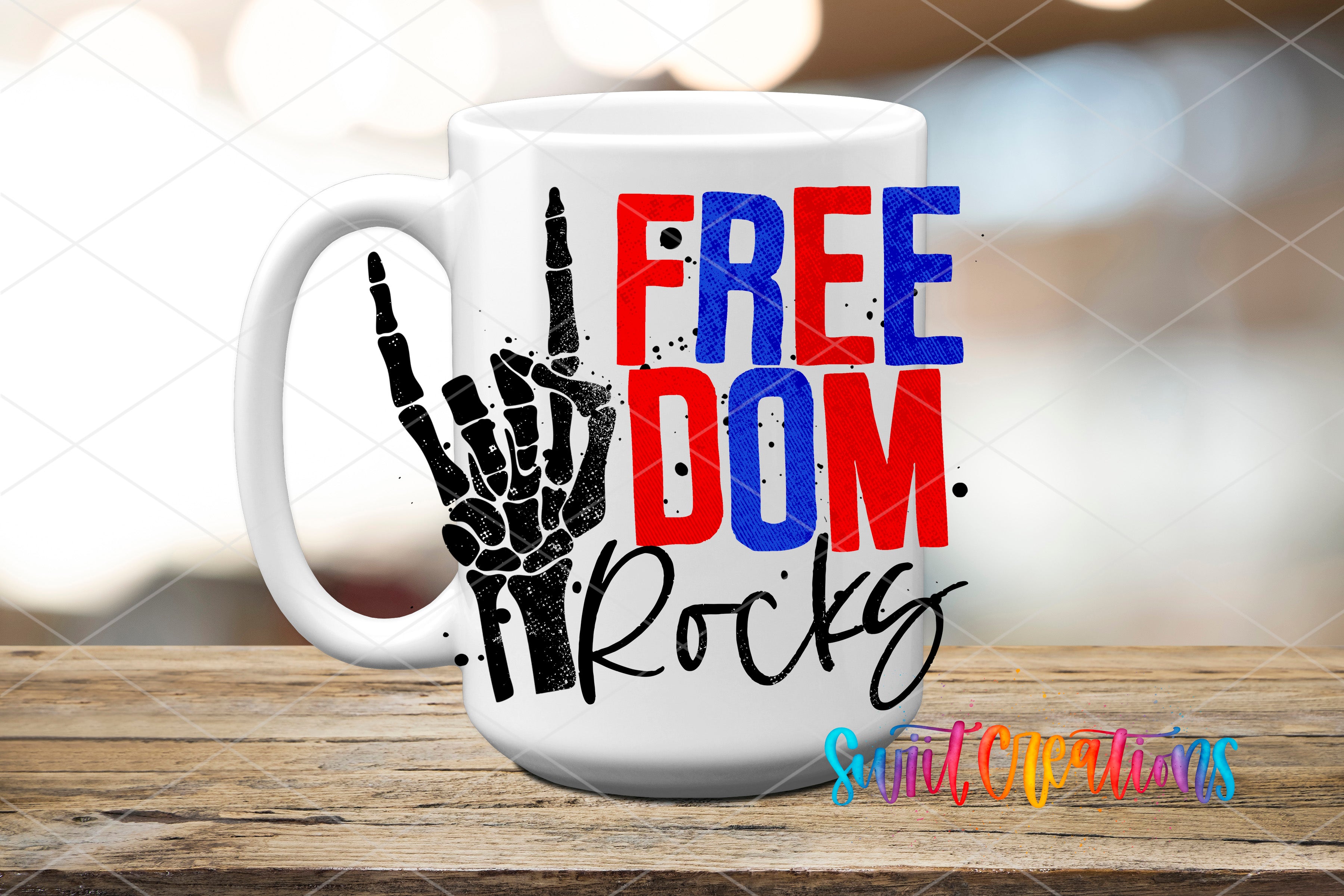 A white mug with the text "FREE DOM ROCKS" printed on it, along with a graphic of a skeleton hand making a rock and hand gesture.