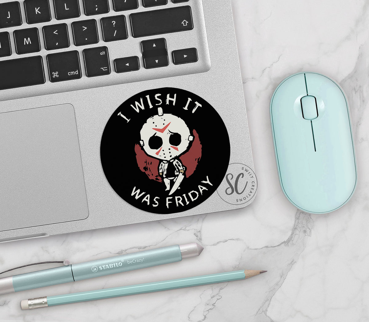I Wish It Was Friday vinyl sticker on a silver laptop next to a mint mouse and pens