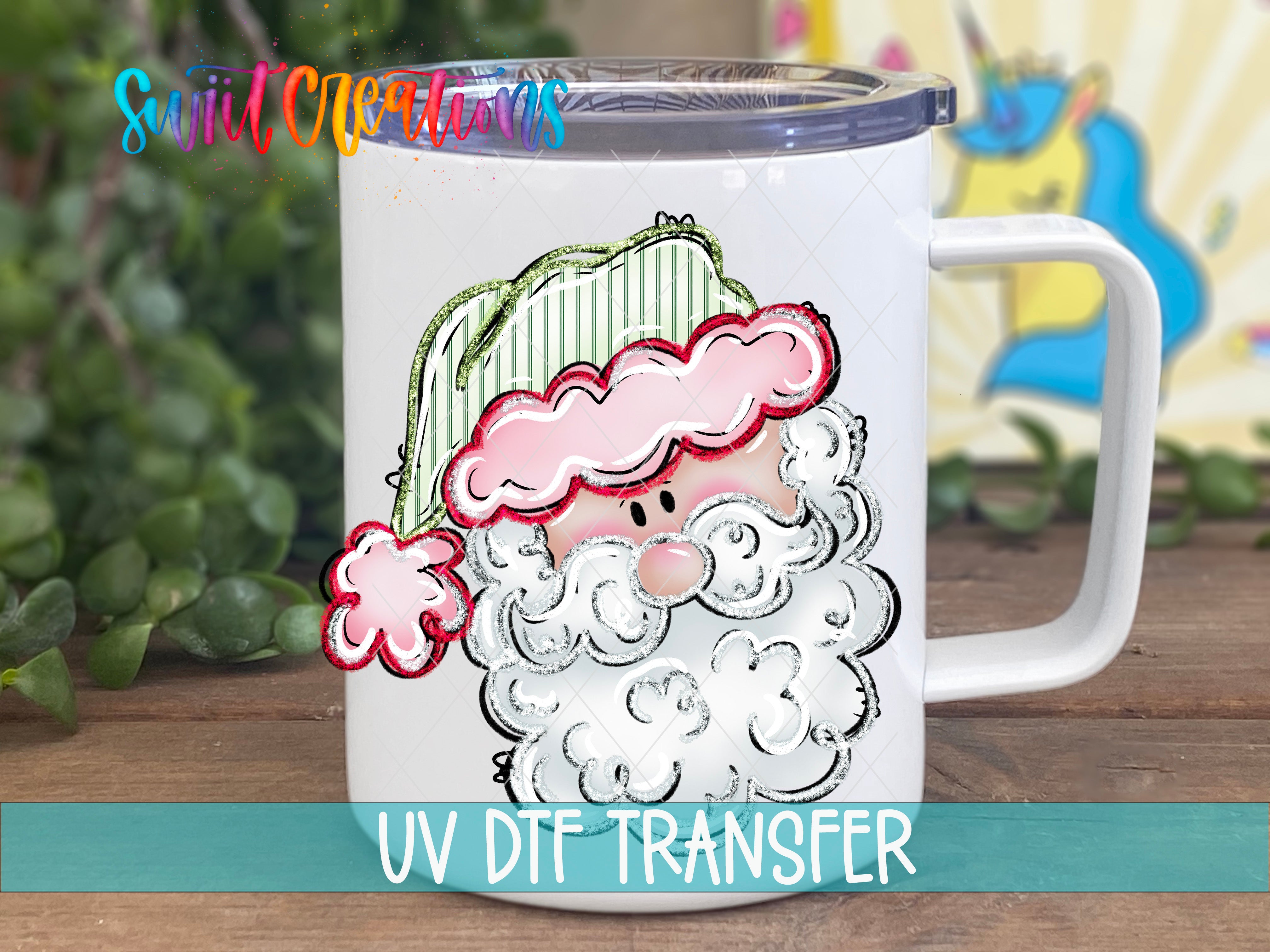A white mug with a colorful Santa Claus design printed on it, sitting on a wooden surface.