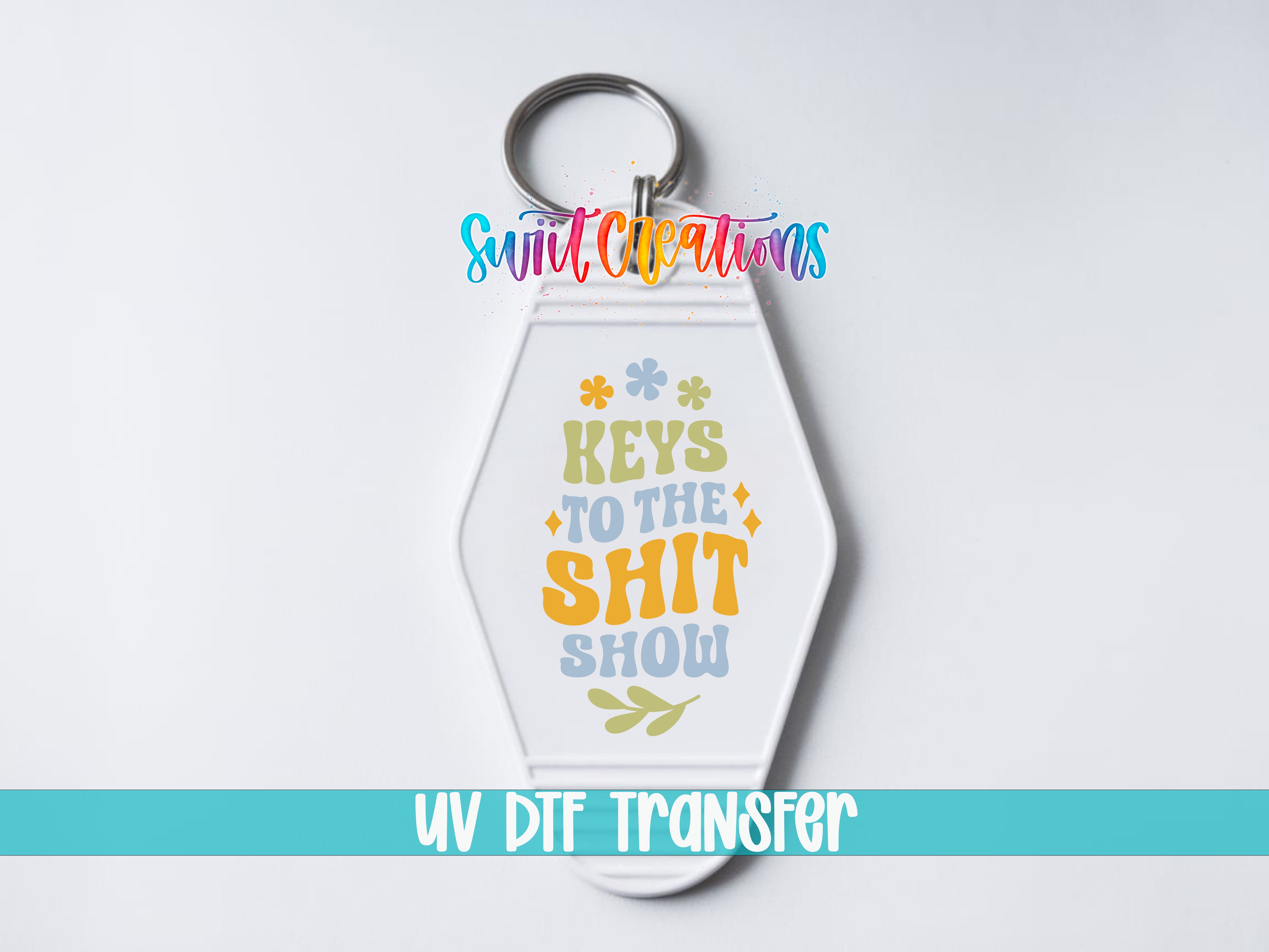 A keychain with a colorful design and text that says "Keys to the shit show" and "UV DDF Transfer".