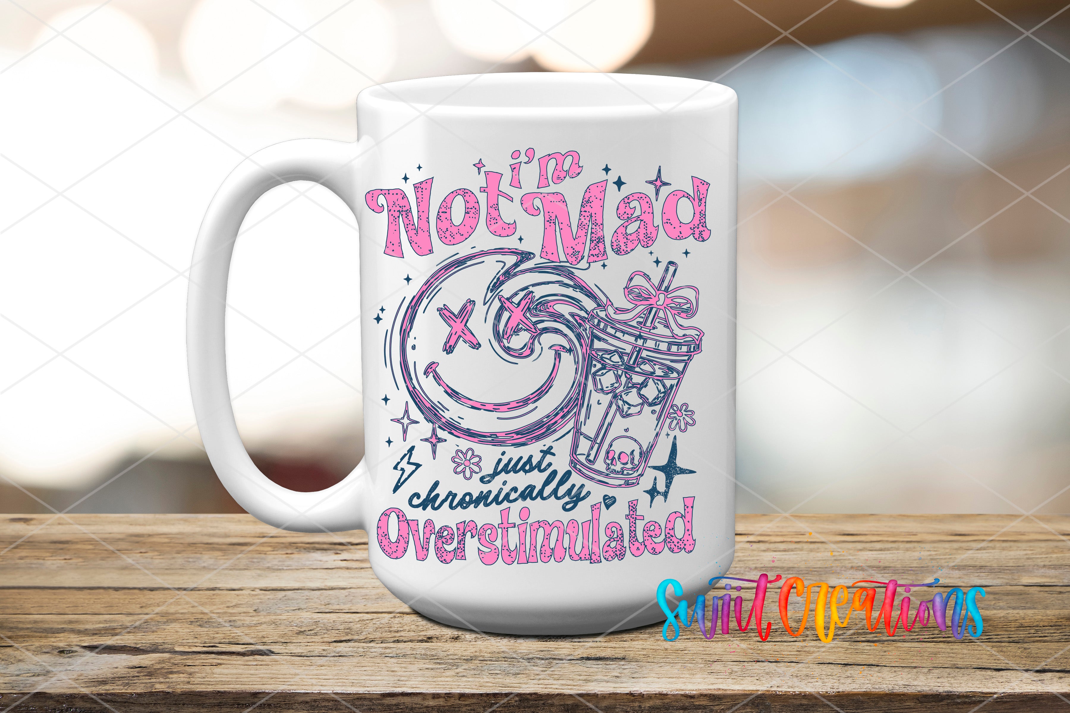 A white ceramic mug with a colorful design and text printed on it, placed on a wooden surface.