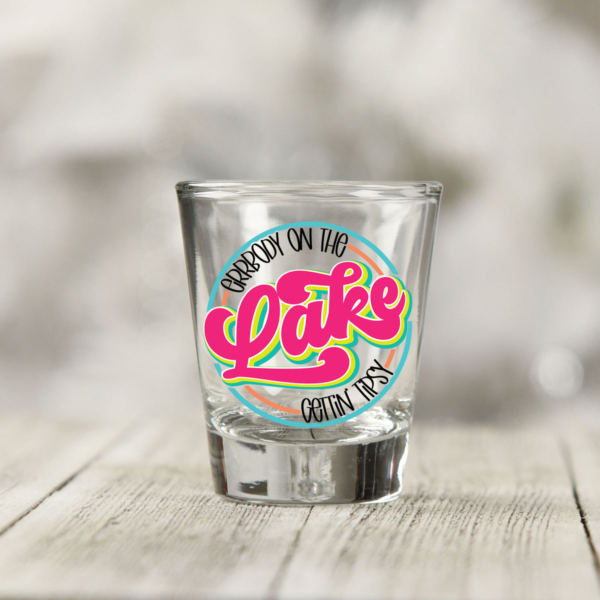 Close-up of the Everybody on the Lake Gettin Tipsy UV DTF transfer on a clear shot glass