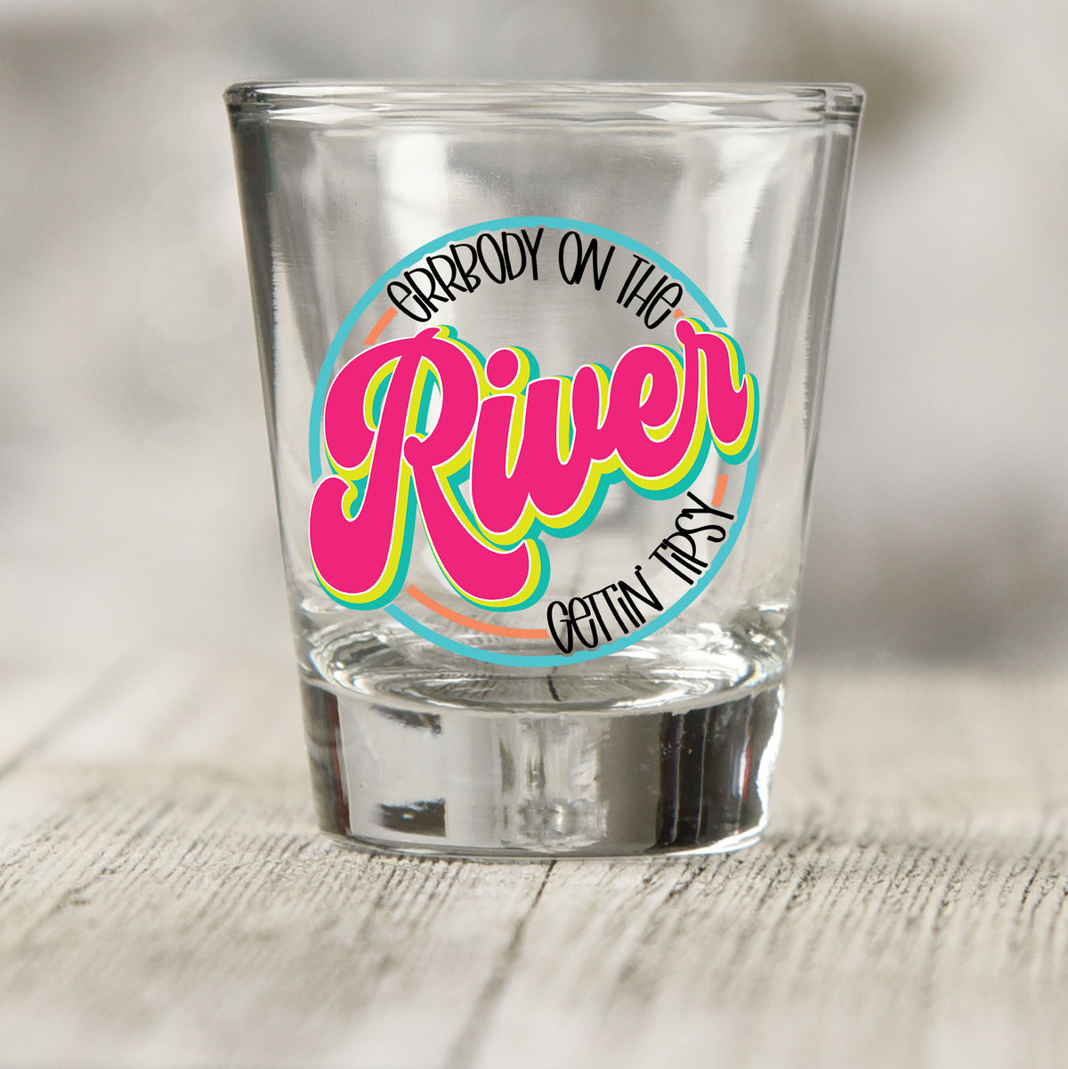 Everybody on the River Gettin Tipsy shot glass UV DTF transfer with retro script inside a circle on a clear shot glass