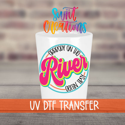 Everybody on the River Gettin Tipsy UV DTF transfer on a white shot glass in front of a brick wall