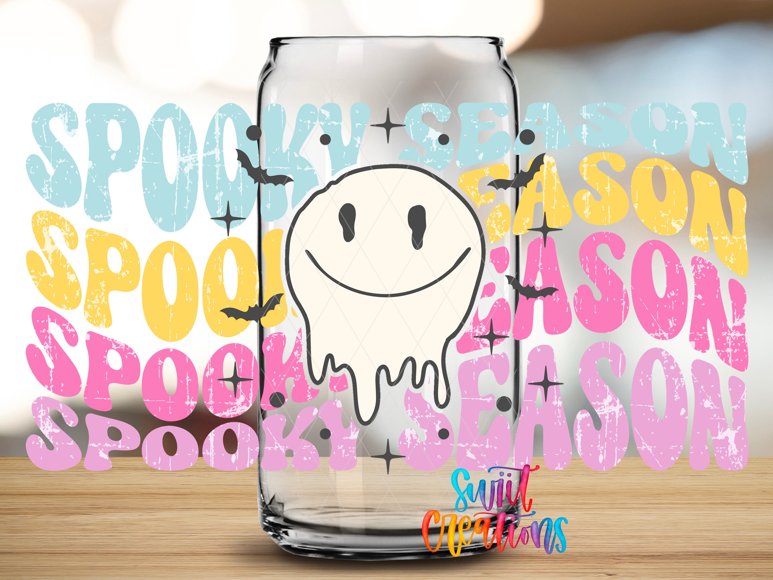 A clear glass jar with a white, smiling ghost-like figure on it, surrounded by the text "SPOOKY SEASON" in various colors and styles.
