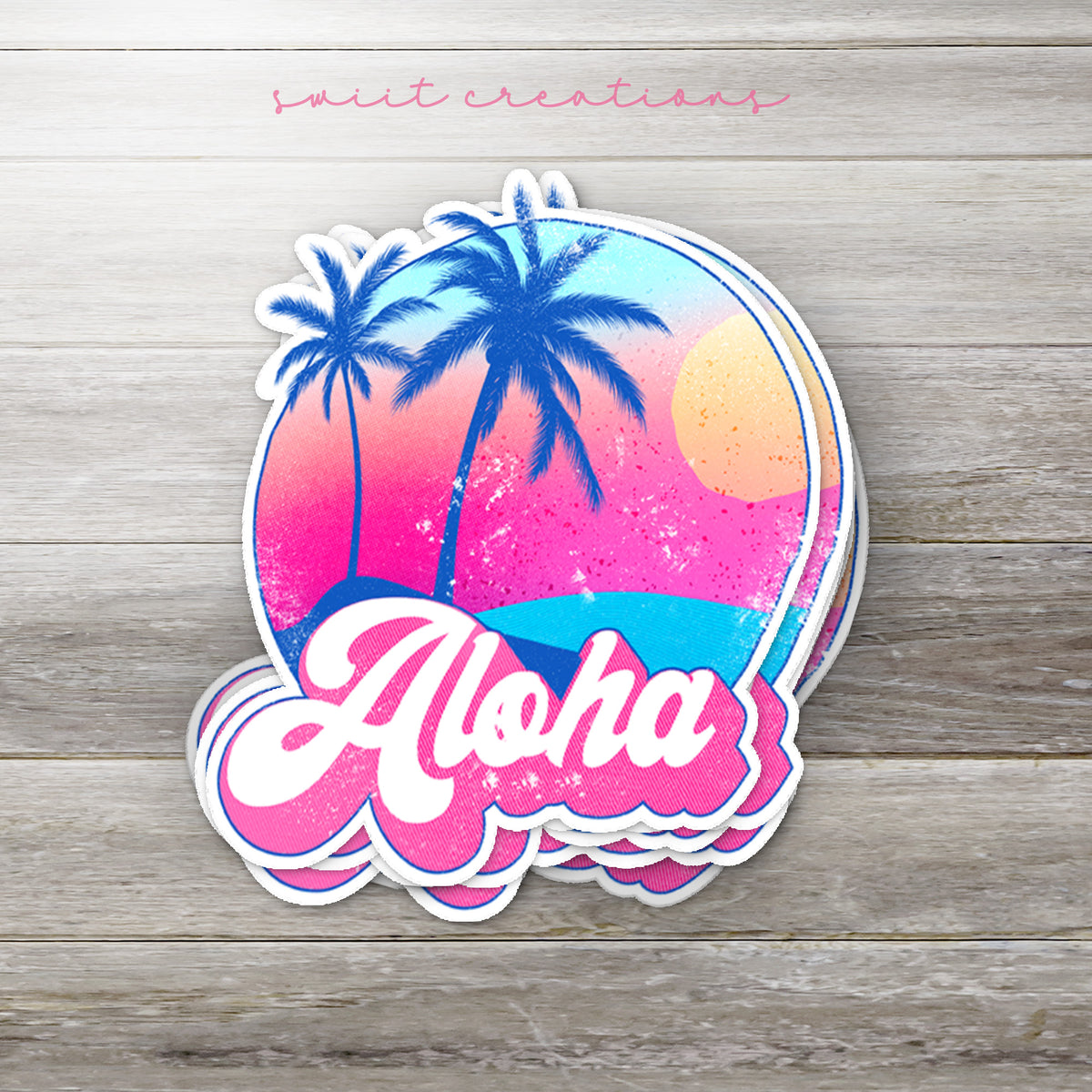 Stack of Aloha glossy stickers on a gray wood table