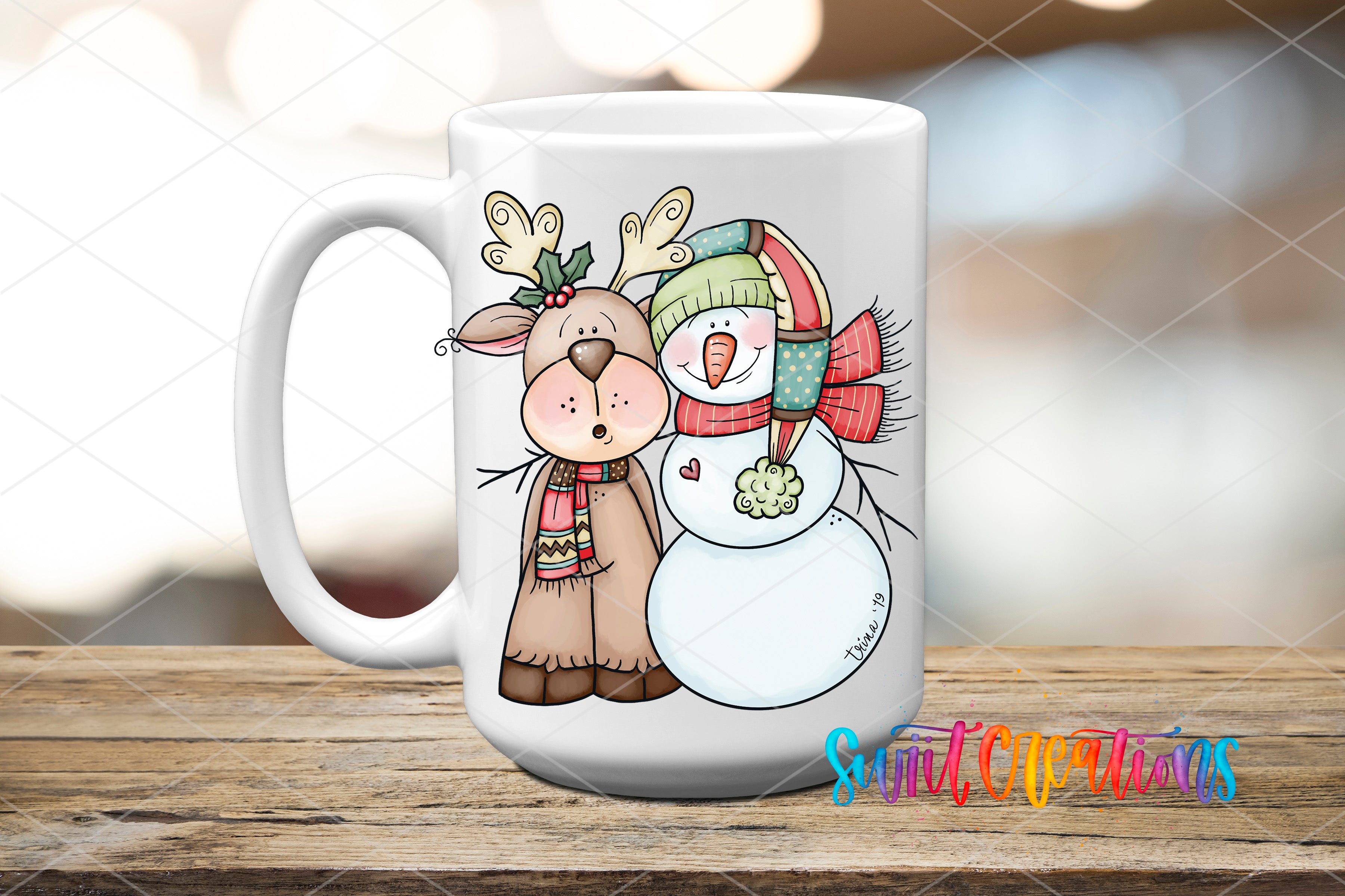 A white mug with a cartoon illustration of a reindeer and a snowman on it, sitting on a wooden surface.