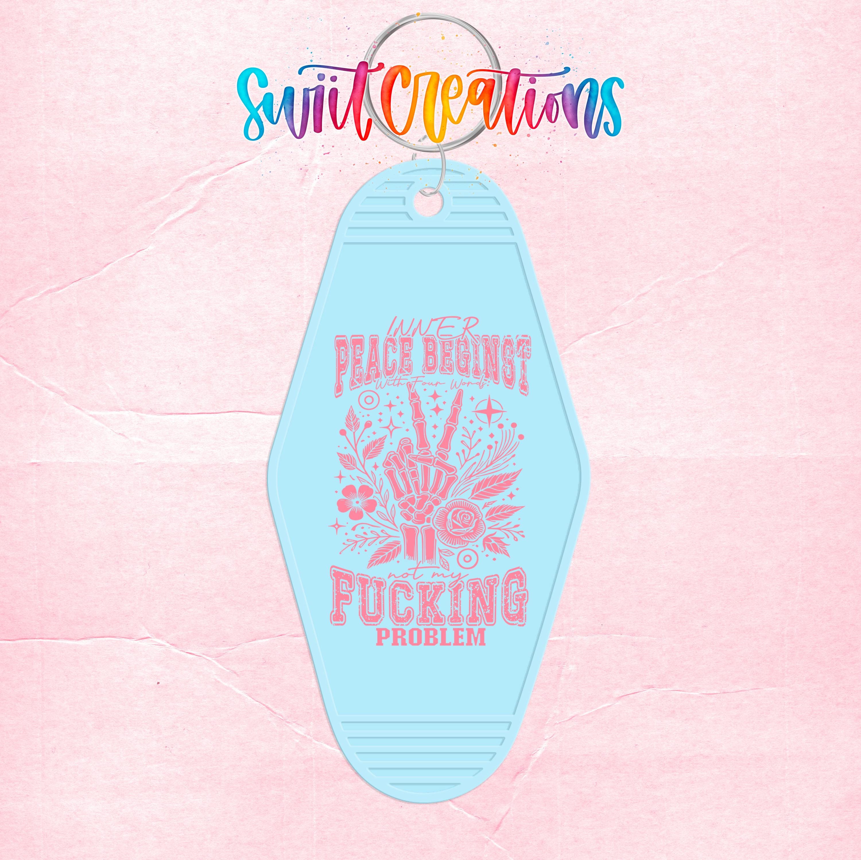 A keychain with a message that says "Peace begins with Fucking problem" in a stylized font.