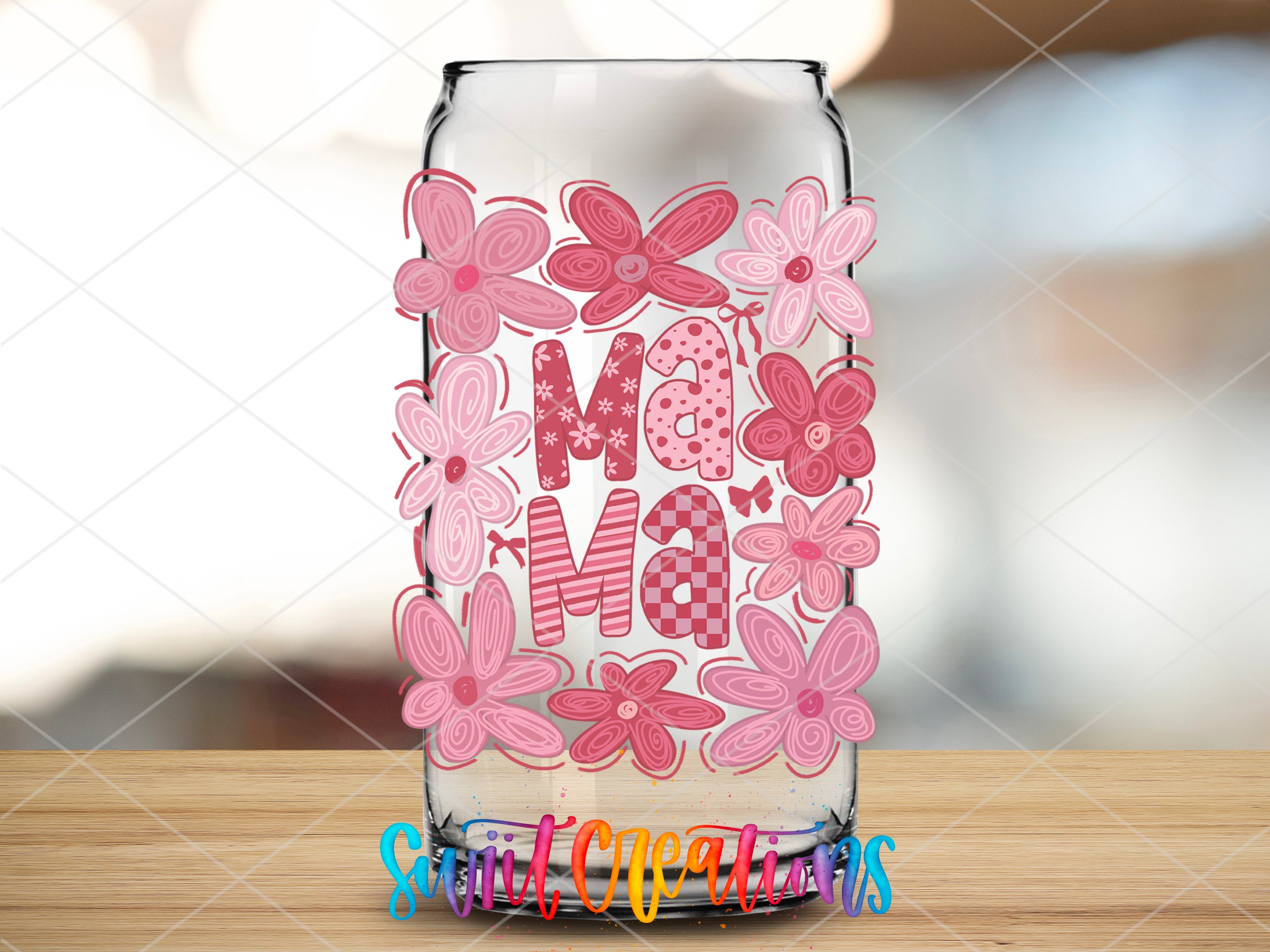 a glass with some flowers on it sitting on a table