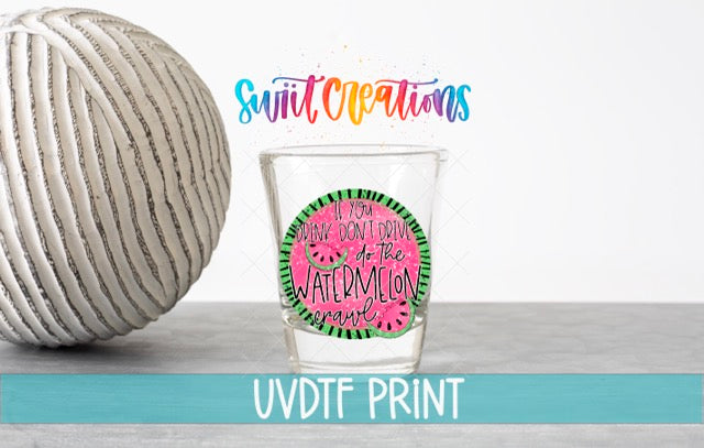 a ball of yarn next to a shot glass
