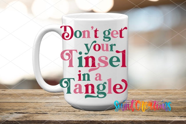 a coffee mug with the words don't get your tinsel in a tangle