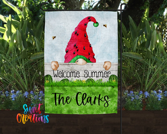 A garden gnome wearing a red hat with a green ball and surrounded by a lush green lawn and colorful flowers.