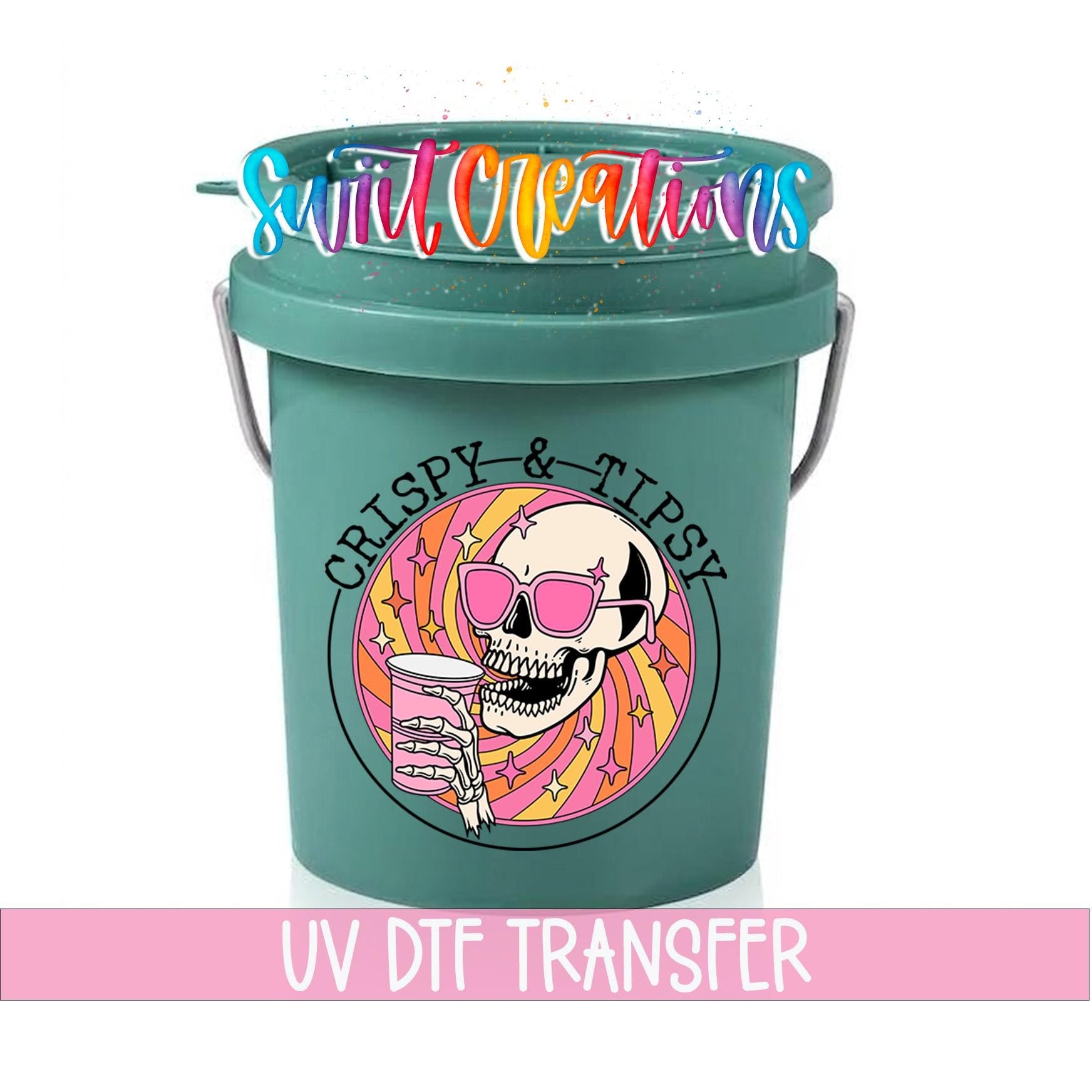 A green bucket with a skull wearing sunglasses and holding a drink, surrounded by colorful designs.