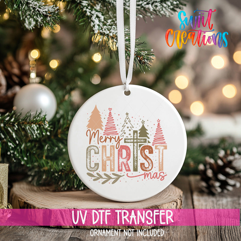 A white Christmas ornament with the text "Merry Christmas" and "Christmas" printed on it, hanging on a decorated Christmas tree.