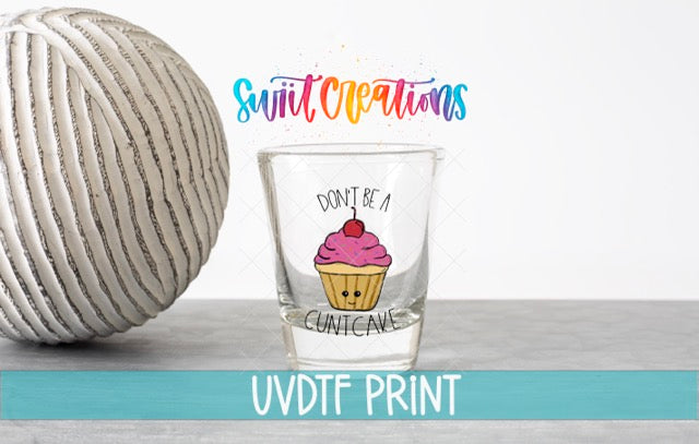 a ball of yarn next to a glass with a cupcake on it