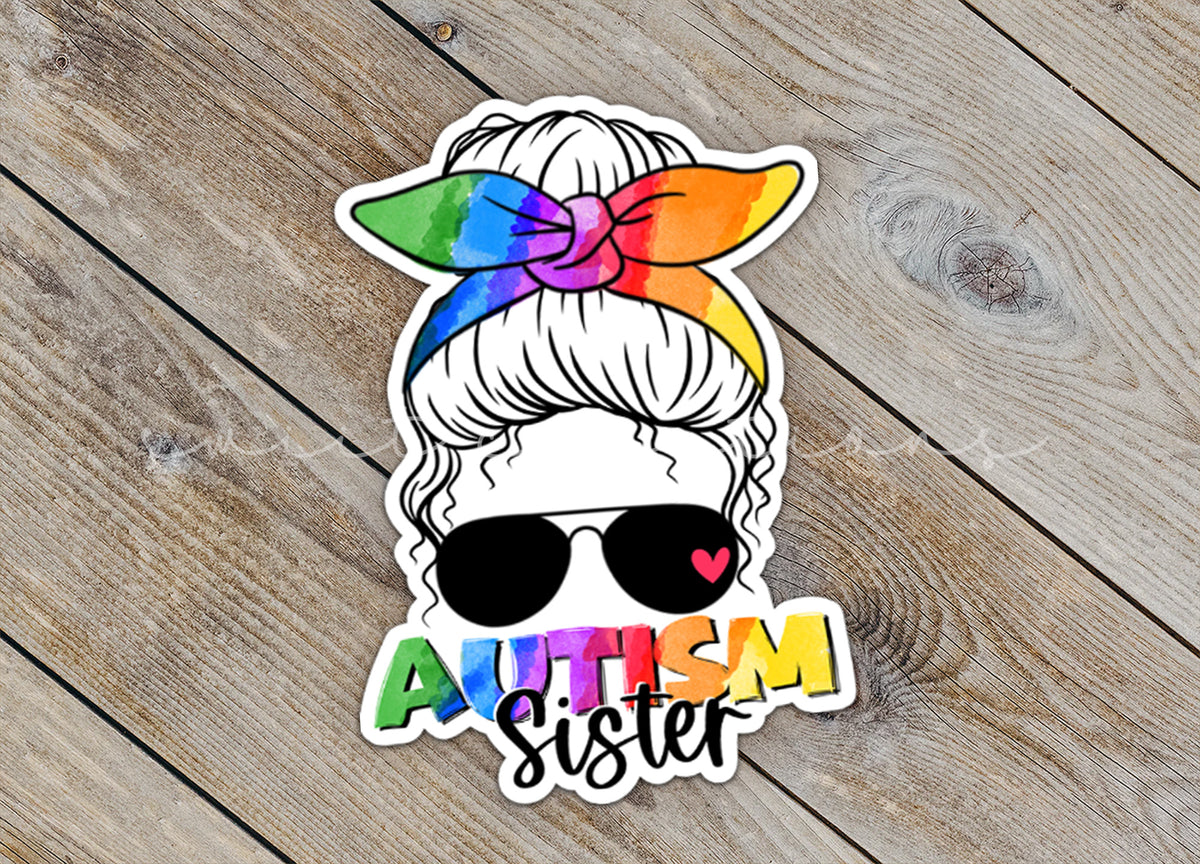 Close-up of the Autism Sister sticker on rustic wood
