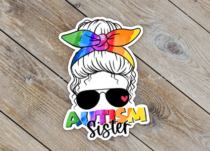 Close-up of the Autism Sister sticker on rustic wood