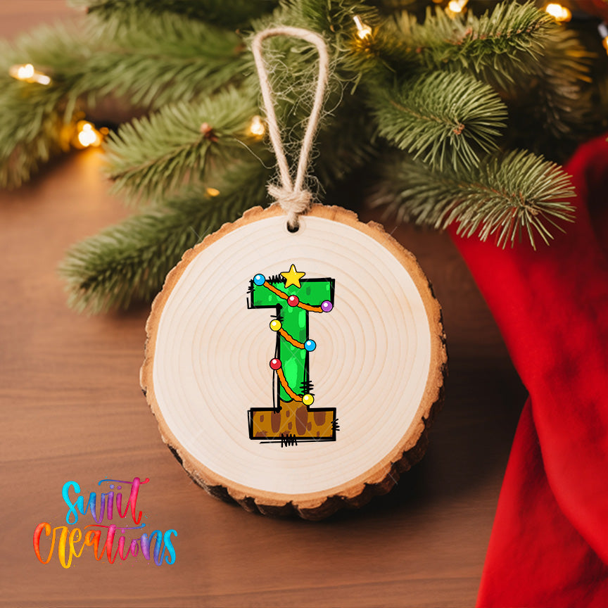 A wooden ornament with a green number 1 on it, hanging on a Christmas tree.