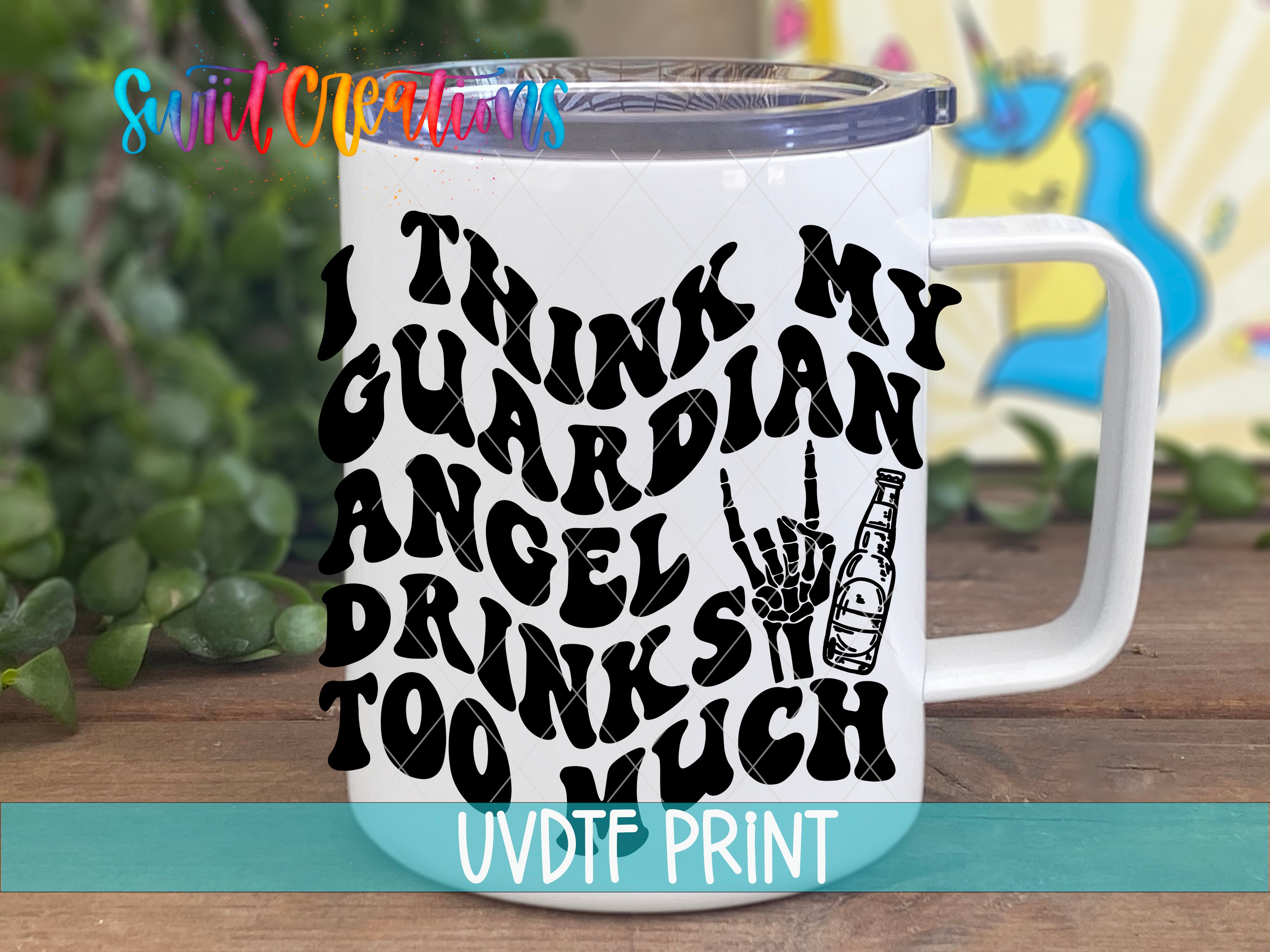 A white mug with a black text design that says "I THINK MY GUARDIAN ANGEL DRINKS TOO MUCH" printed on it.