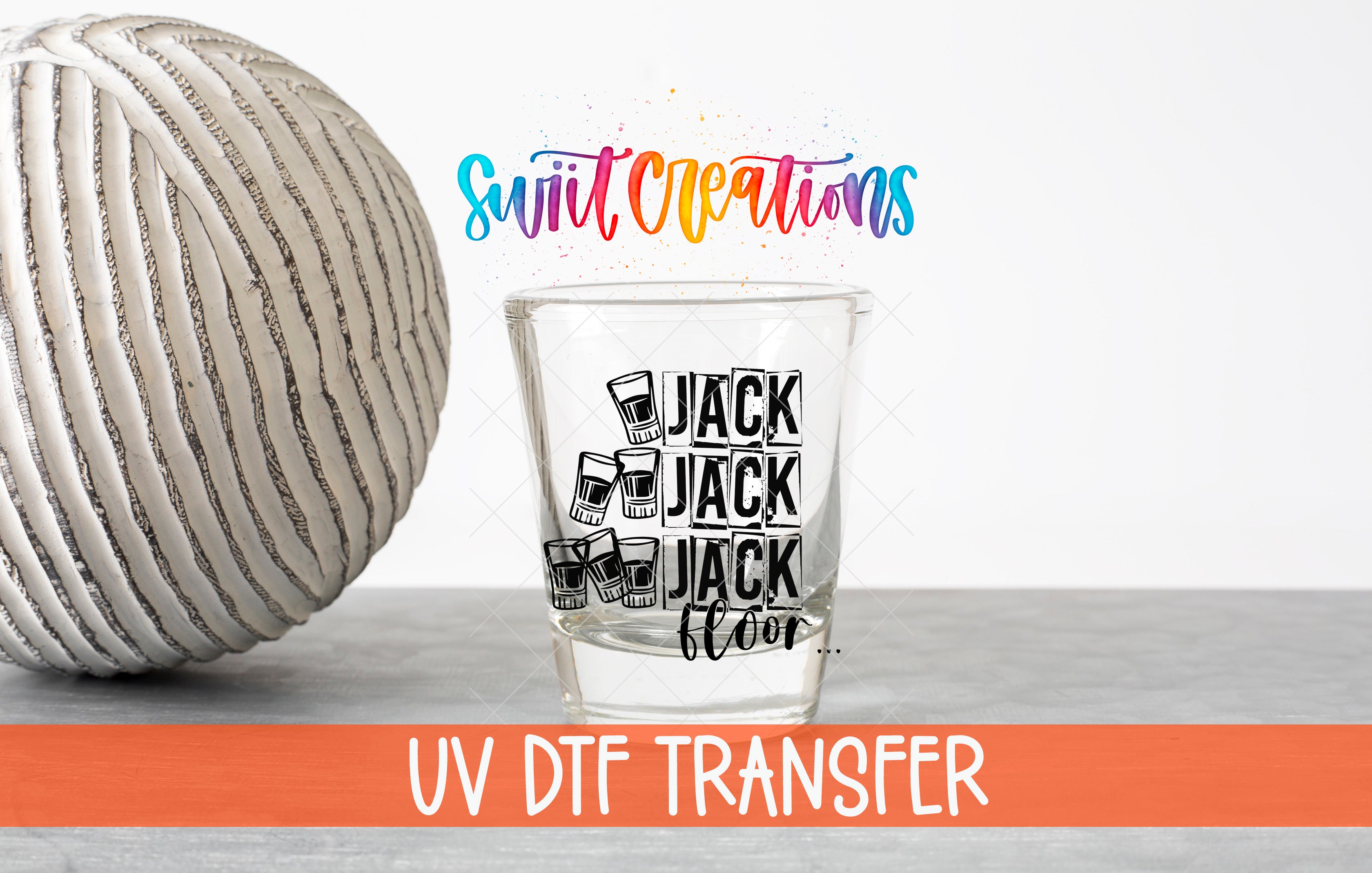 a shot glass with a design and text, along with a large white ball and a rainbow-colored text overlay.