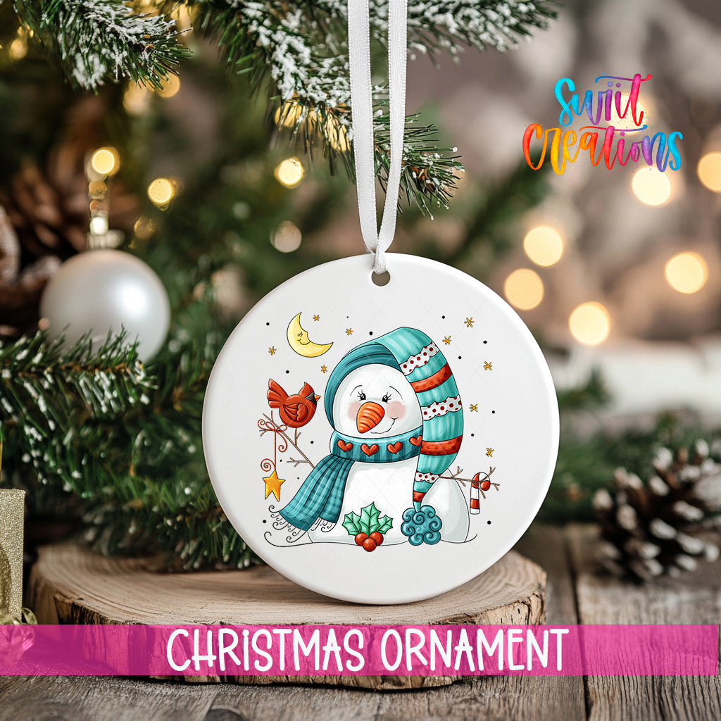 A white Christmas ornament featuring a snowman with a scarf and hat, surrounded by snowflakes and stars, hangs from a tree branch.