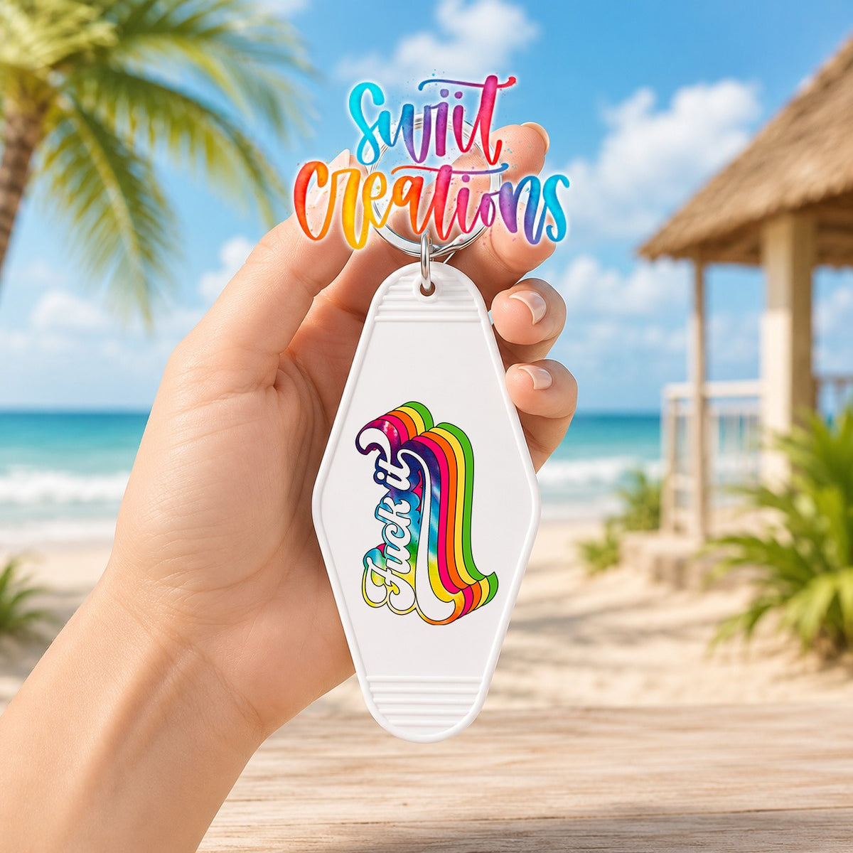 Hand holding a white motel keychain with the F*ck It UV DTF transfer at the beach