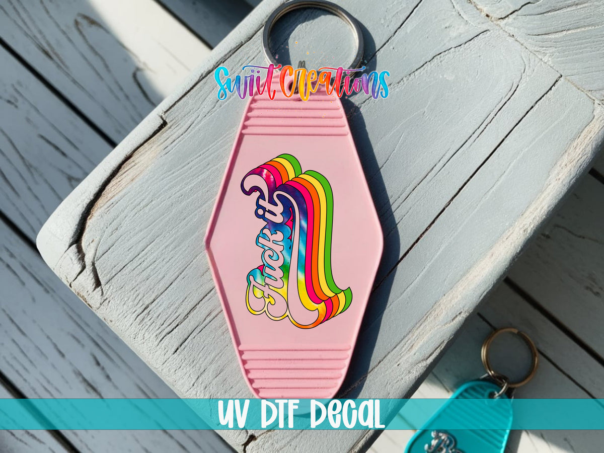 F*ck It UV DTF transfer on a pink motel keychain on a wood board