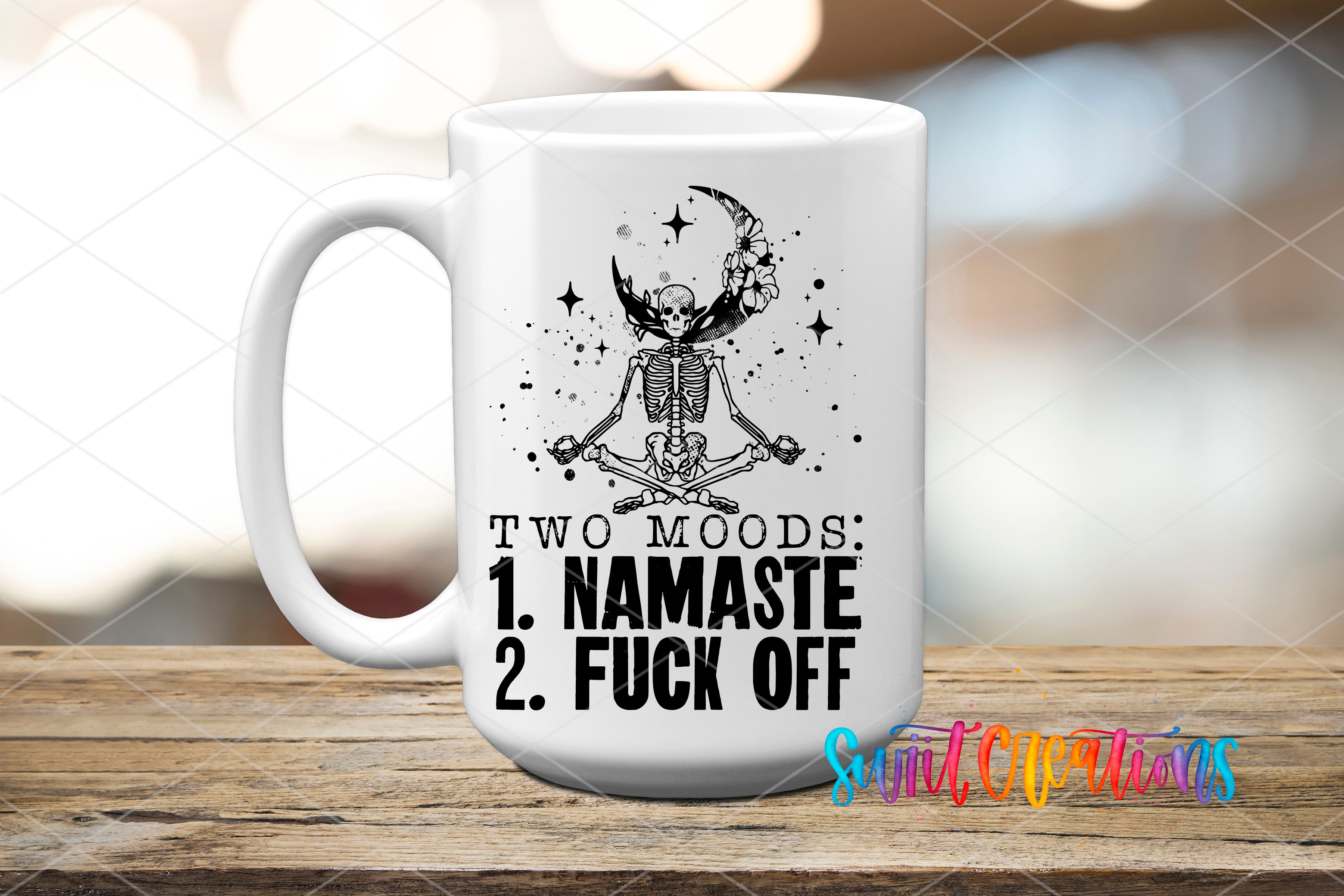 A white ceramic mug with a black and white illustration of a skeleton in a meditative pose, along with the text "TWO MOODS: 1. NAMASTE 2. FUCK OFF" printed on it.