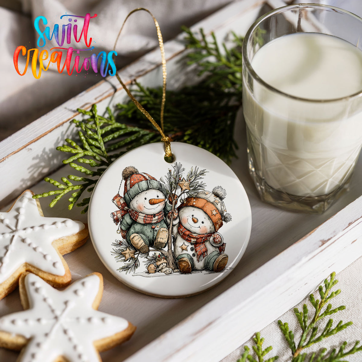 a festive scene with a snowman ornament, cookies, and a glass of milk on a white tray.