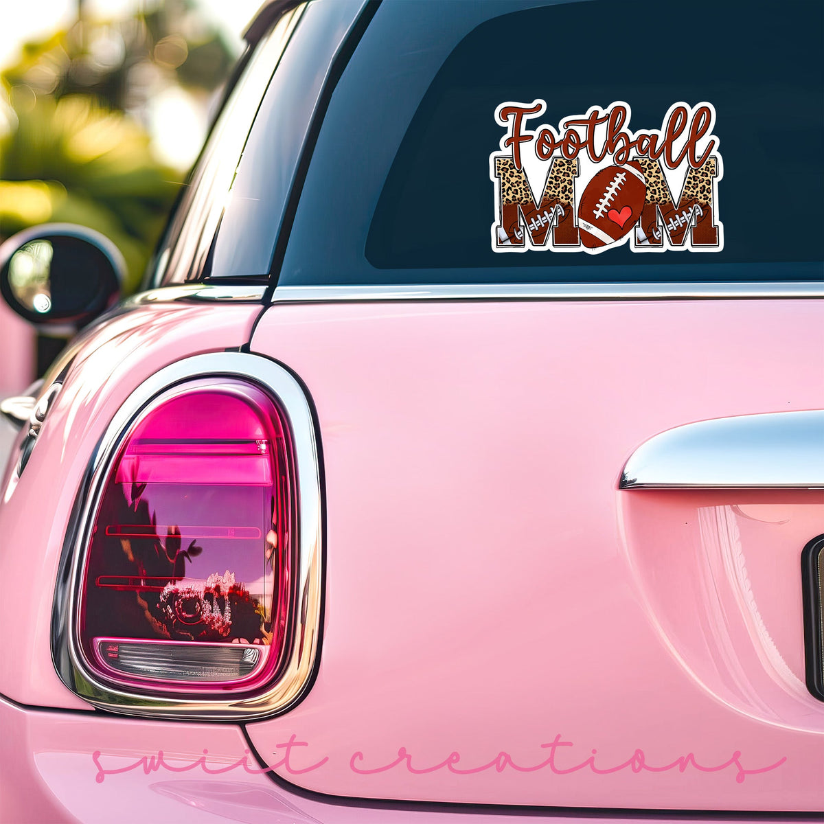 Football Mom sticker on the back window of a pink car
