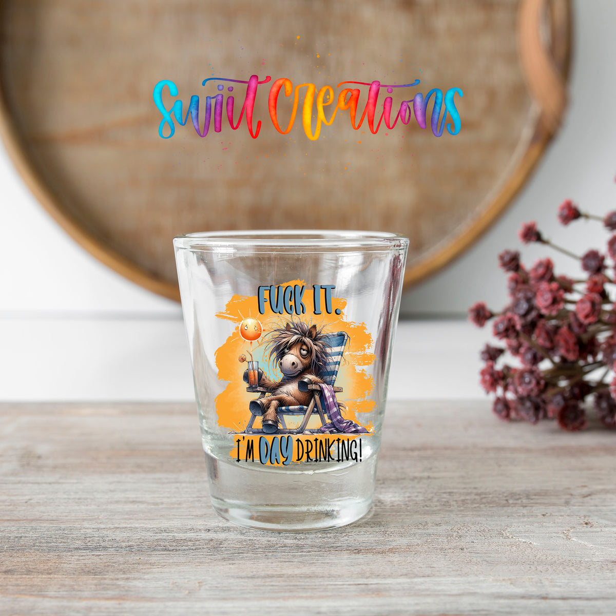F*ck It I'm Day Drinking shot glass transfer on a clear glass beside a wooden barrel and dried flowers