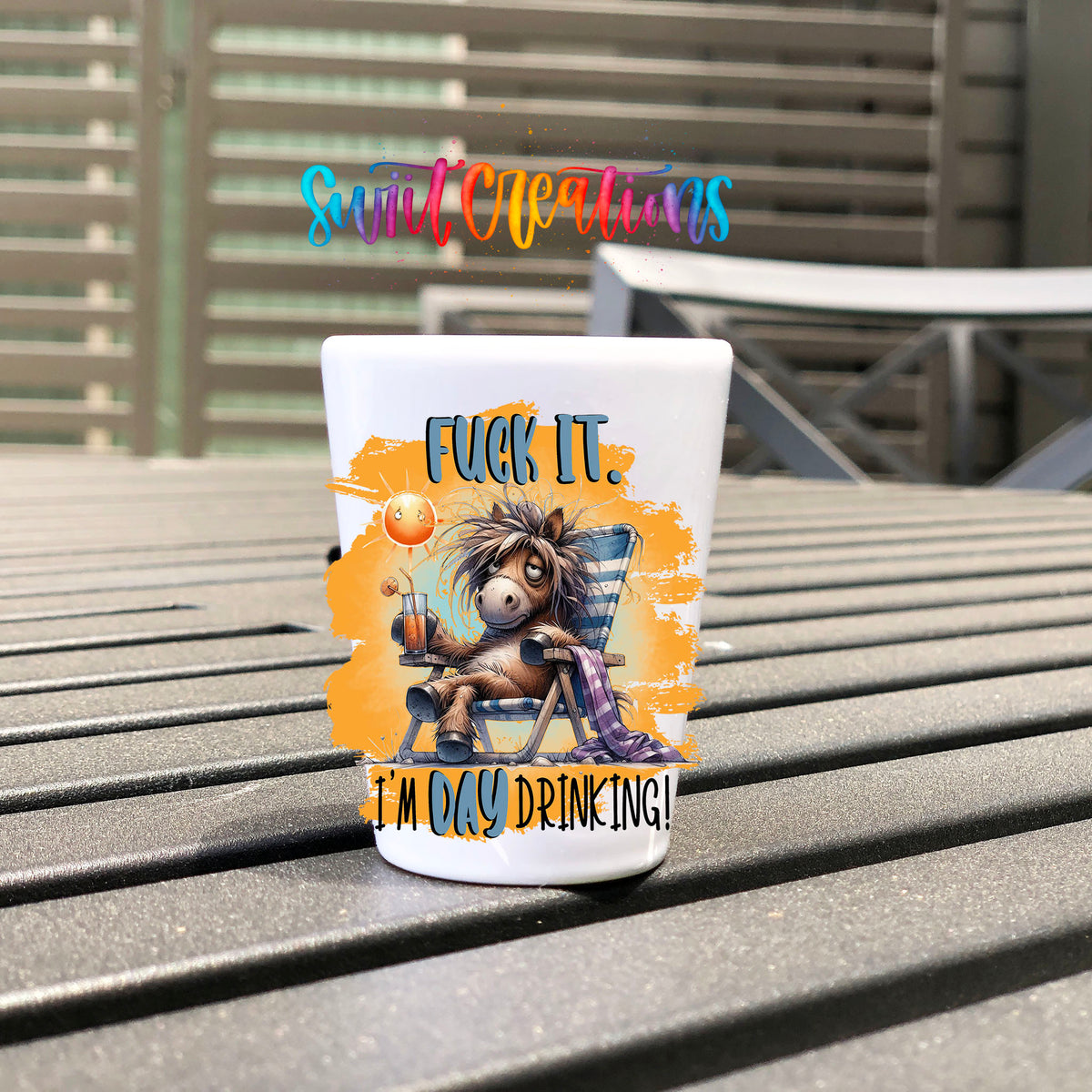 F*ck It I'm Day Drinking UV DTF transfer on a white shot glass on an outdoor patio table