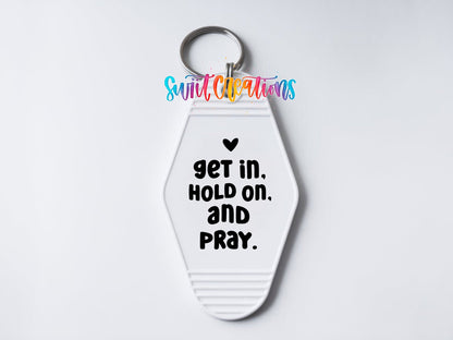 Close-up of the Get In Hold On and Pray UV DTF transfer on a white motel keychain