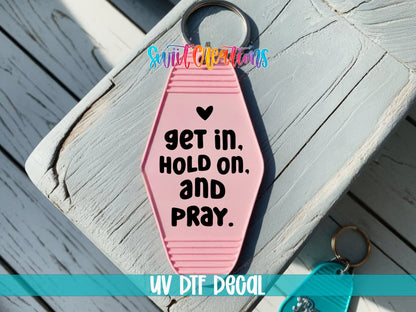 Get In Hold On and Pray UV DTF transfer on a pink motel keychain on a wood board
