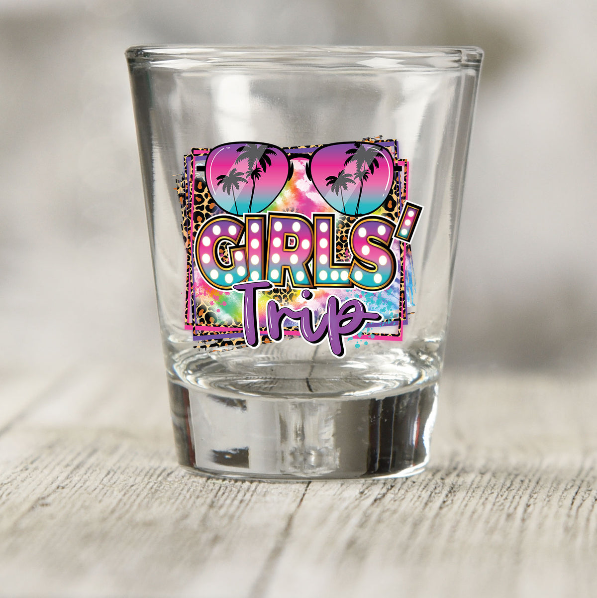 Girls Trip shot glass UV DTF transfer with heart sunglasses, tie-dye, and leopard print on a clear shot glass