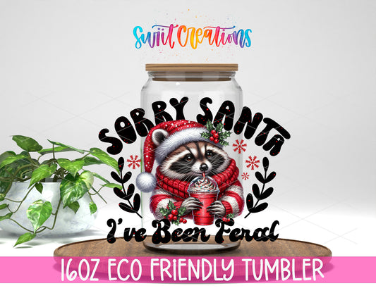 Sorry Santa I Have Been Feral Raccoon design on a 16 oz clear glass tumbler with bamboo lid