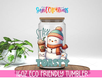 Stay Toasty Snowman design on a 16 oz clear glass tumbler with bamboo lid