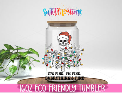 Everything Is Fine Christmas Skeleton design on a 16 oz clear glass tumbler with bamboo lid