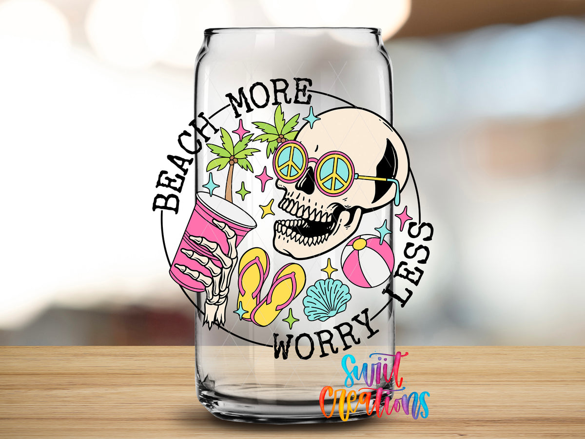 Beach More Worry Less Skull design close-up on a clear glass can tumbler
